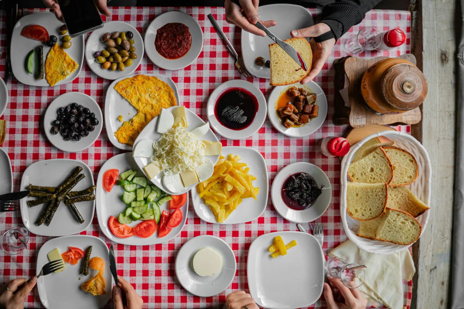 A family breakfast spread across a checked tablecloth, seen from above